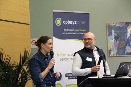 Atelier collaboratif chez Optesys Conseil : des participants échangent autour d’une présentation projetée, dans une salle lumineuse au cadre convivial et moderne.